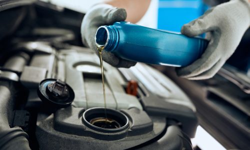 Close-,Up,Of,Mechanic,Pouring,Motor,Oil,While,Doing,Car
